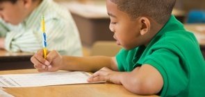 Ilustração de uma criança sentada fazendo prova