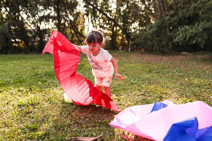Fotografia de crian&ccedil;a brincando com materiais de largo alcance em um parque.