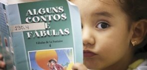 Menina pequena com um livro de contos e fábulas na frente