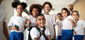 Um grupo de alunos diversos sorriem para a foto