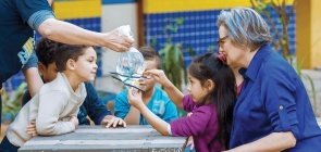 Foto de professora sentada com um grupo de alunos