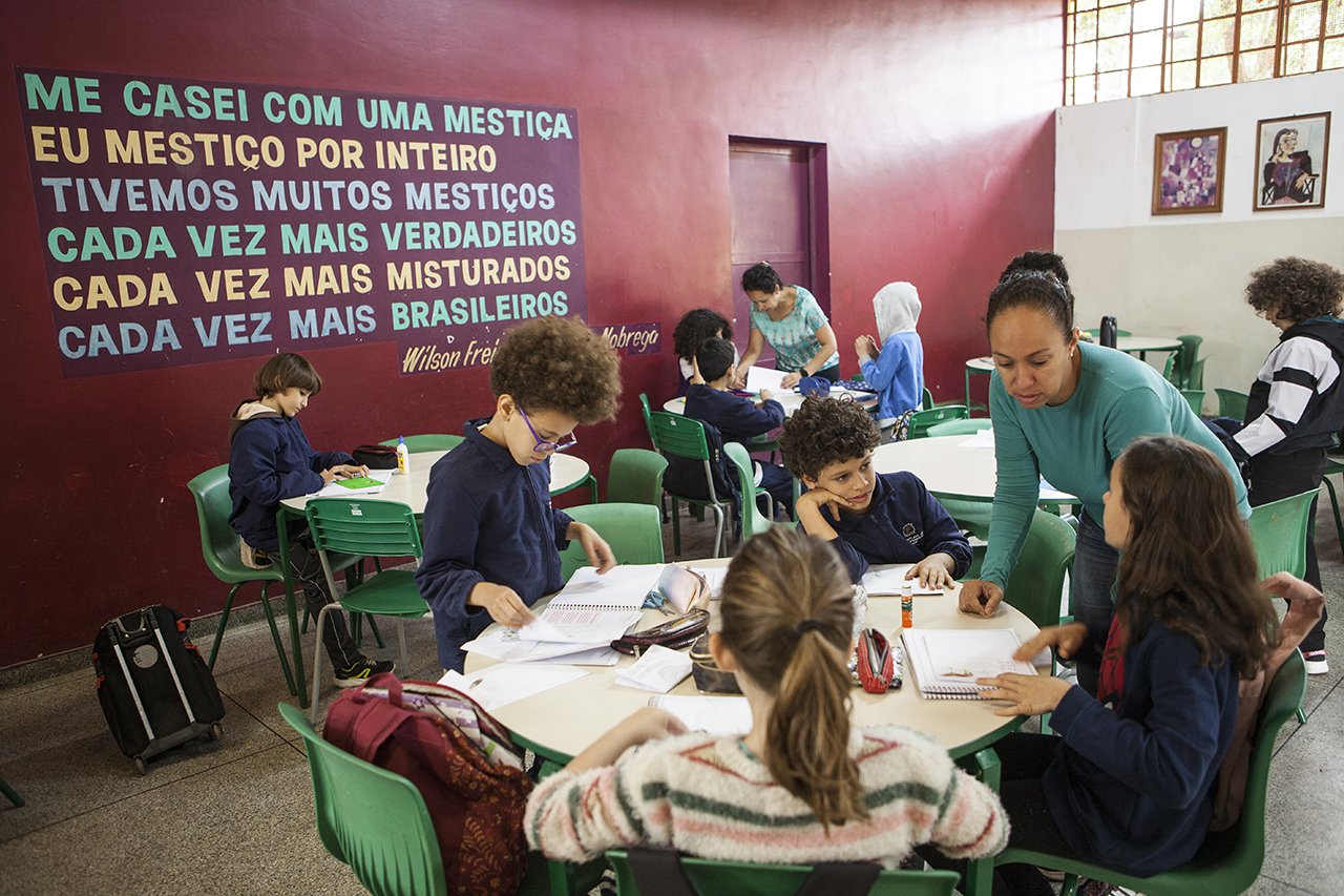 Alunos trabalham em grupo com a ajuda de uma professora tutora na escola Desembargador Amorim Lima, em S&atilde;o Paulo