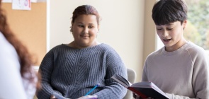 Roda de alunos dos Anos Finais. Um estudante faz leitura em voz alta