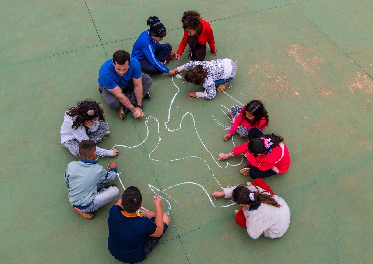 Os alunos de Luiz Gustavo Bonatto Rufino discutem em volta dos contornos desenhados em quadra