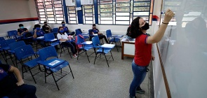 Professora dá aula com protocolos contra a covid-19