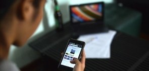 Mulher olha para tela do celular