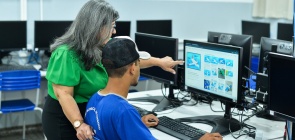 Foto de professora apoiando aluno durante atividade de educação financeira