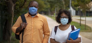 Um homem e uma mulher caminham com mochilas nas costas