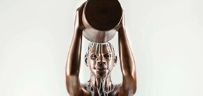 Estátua de bronze, um homem oga um balde de tinta branca em si