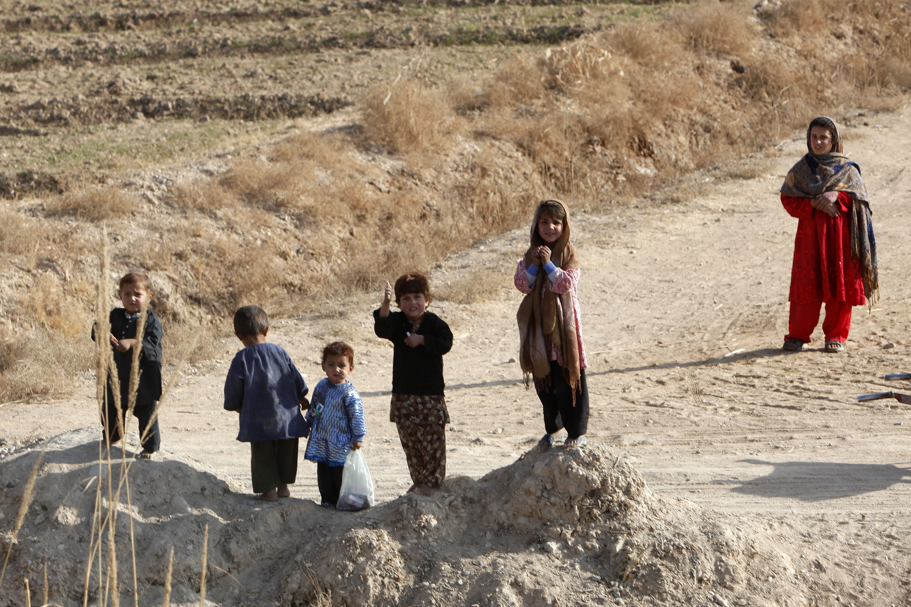 Durante a passagem de um comboio americano (n&atilde;o mostrado na foto), algumas crian&ccedil;as acenam e observam os soldados. Ex&eacute;rcito dos Estados Unidos (Sargento Brandon Owen). Janeiro de 2011.