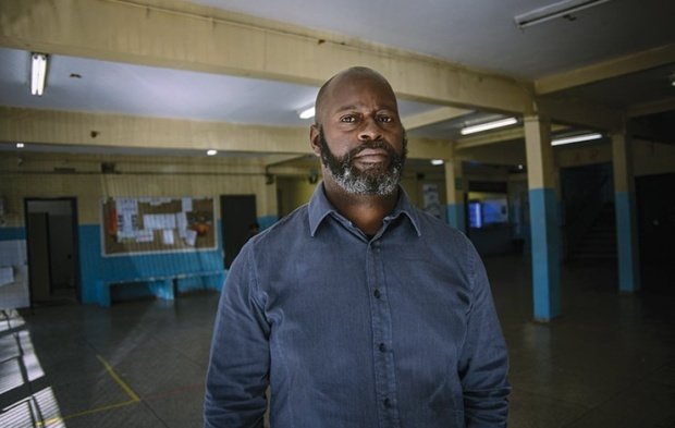 Homem negro, veste camisa social azul