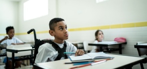 Alunosem sala de aula, incluindo um garoto com deficiência