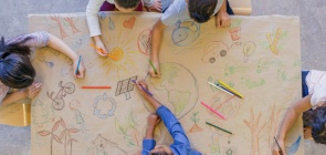 crianças desenham em um cartaz coletivo imagens relacionadas à educação ambiental