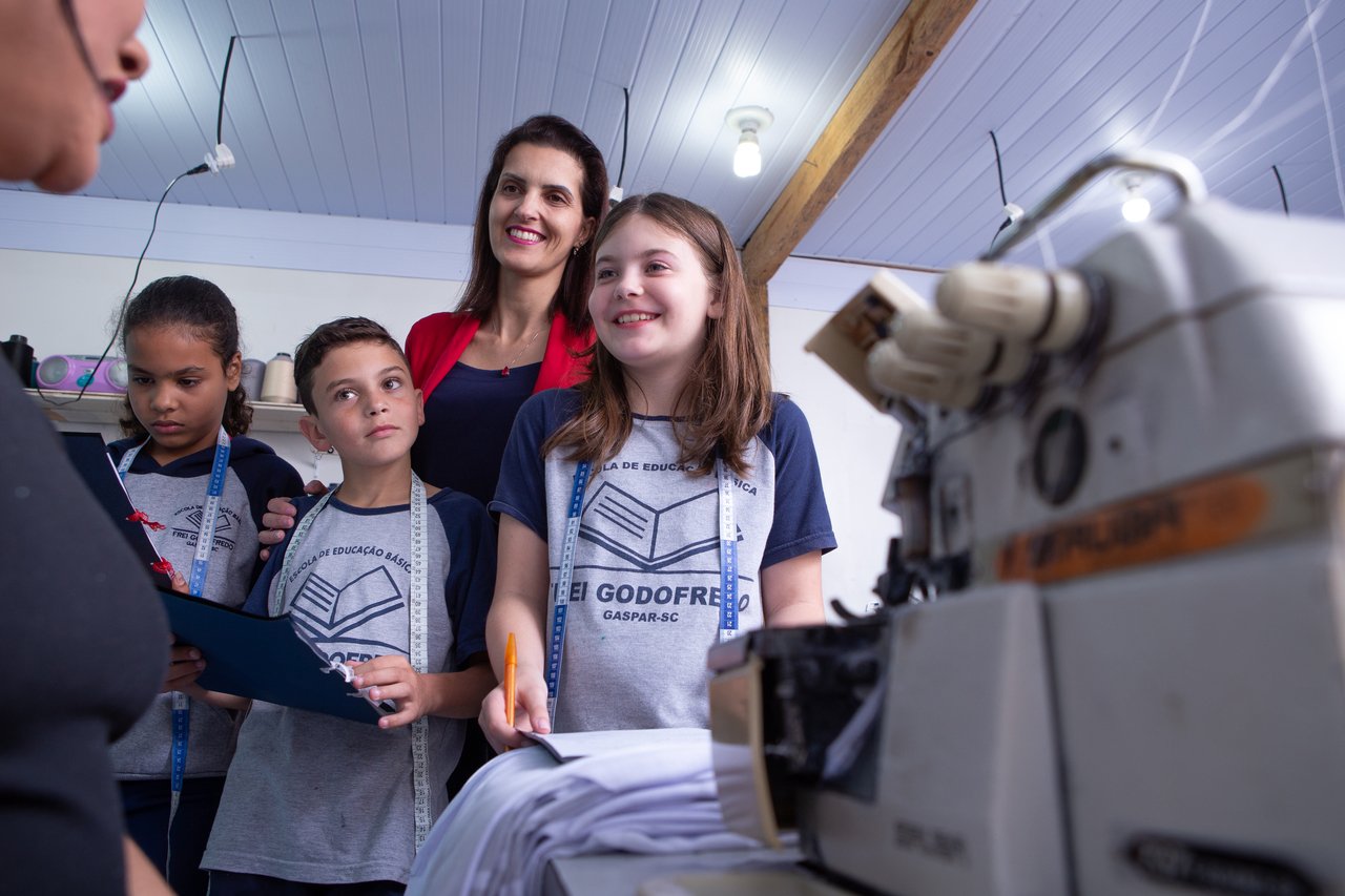 A professora Jussara Schmitz e seus alunos visitam uma oficina de costura em Gaspar (SC) para o projeto Costurando a Matem&aacute;tica