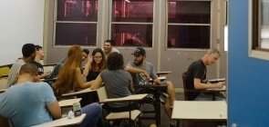 Estudantes universitários conversam em sala de aula