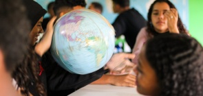alunos observam um globo giratório