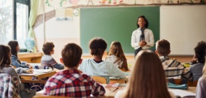 foto colorida de sala de aula com alunos e professora