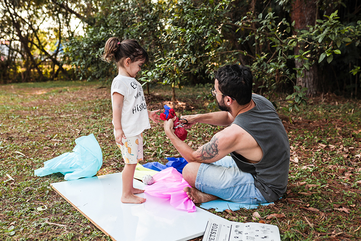 Fotografia de crian&ccedil;a brincando com materiais de largo alcance em um parque ao lado de seu pai.